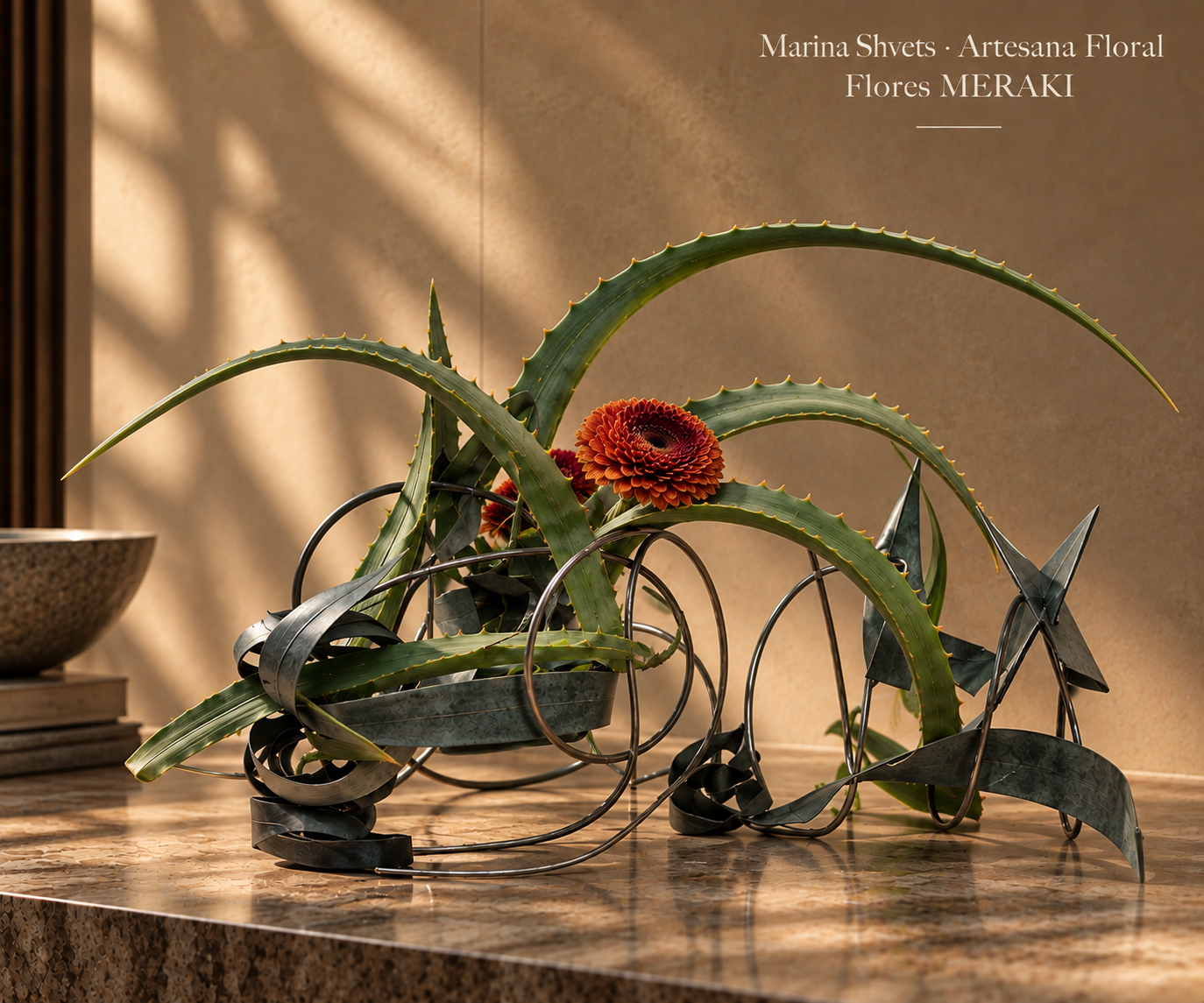 Ikebana escultórica con aloe y estructura oscura