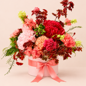Caja Rosa Meraki con flores rosas, rojas y melocotón sobre fondo pastel